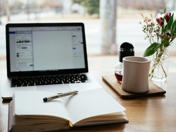 MacBook Pro cerca de un libro blanco abierto